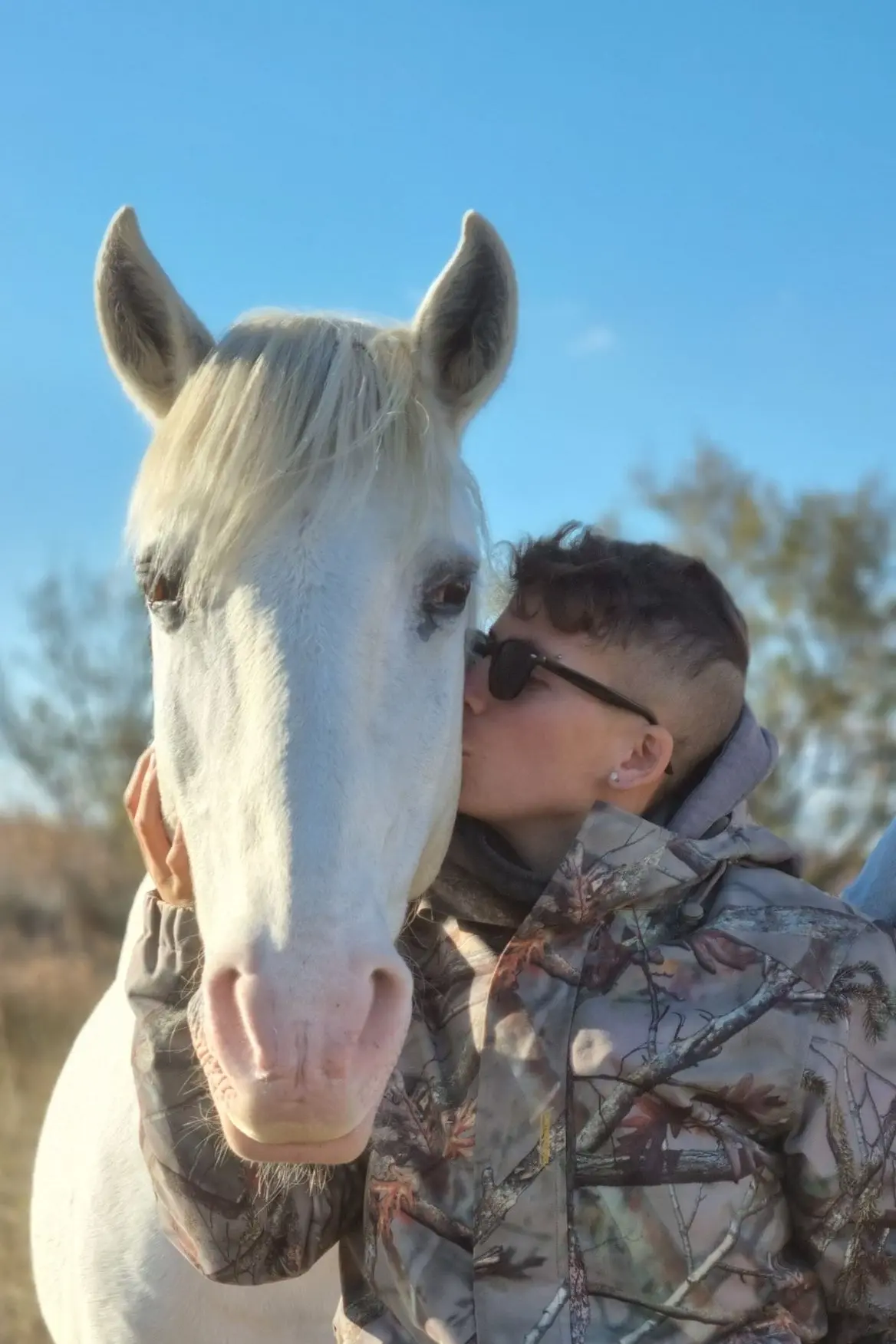 Moment complice entre une personne et un cheval camarguais, capturé en Camargue par La Fadaise.